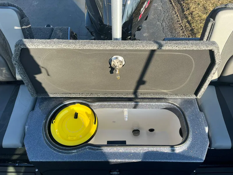 Slide: The Image of 2025 Lund 189 Tyee GL boat storage compartment with open lid and yellow container. - 12