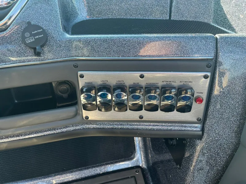Slide: The Image of Control panel of 2025 Lund 189 Tyee GL boat with switches and metallic finish. - 22