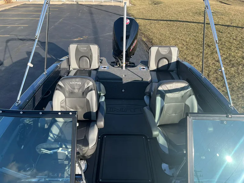 Slide: The Image of 2025 Lund 189 Tyee GL boat interior with four seats and outboard motor. - 8