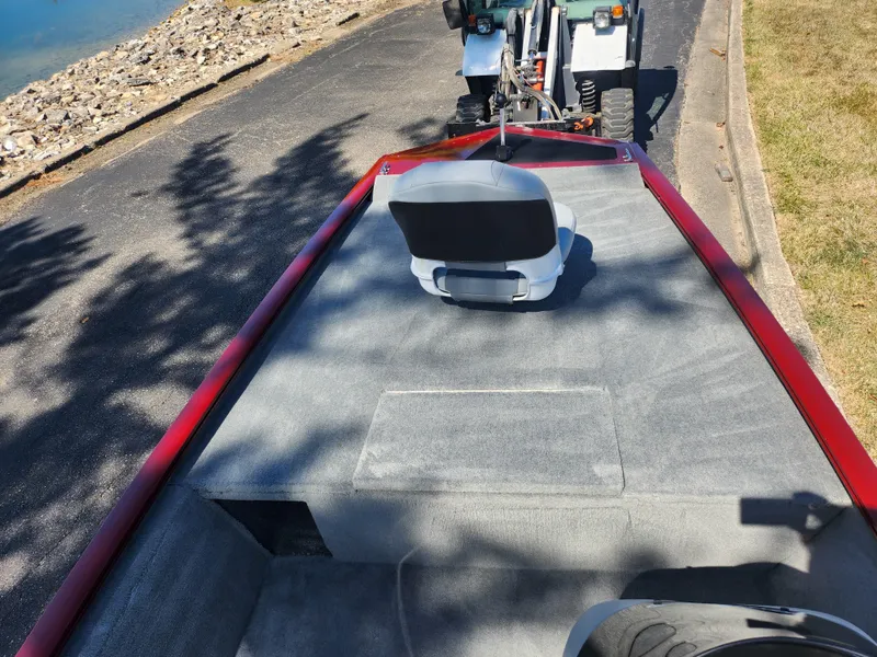 Slide: The Image of 2018 Tracker Pro 170 boat on trailer near water, featuring a single seat and red trim. - 13