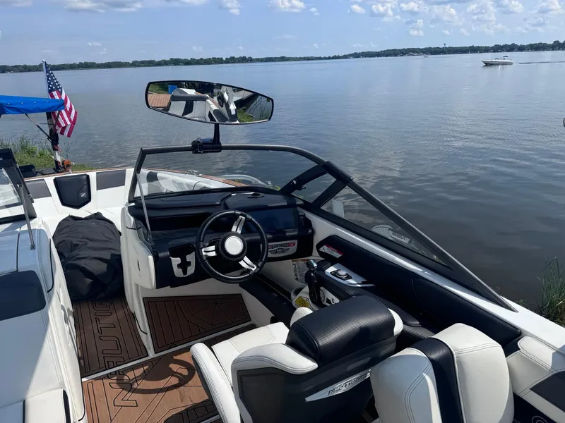 Slide: The Image of 2018 Nautique G23 boat interior with lake view and American flag. - 7