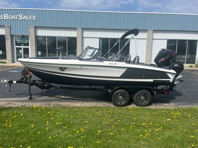 Slide: The Image of 2025 Lund 202 Pro-V GL boat on trailer outside sales building. - 1