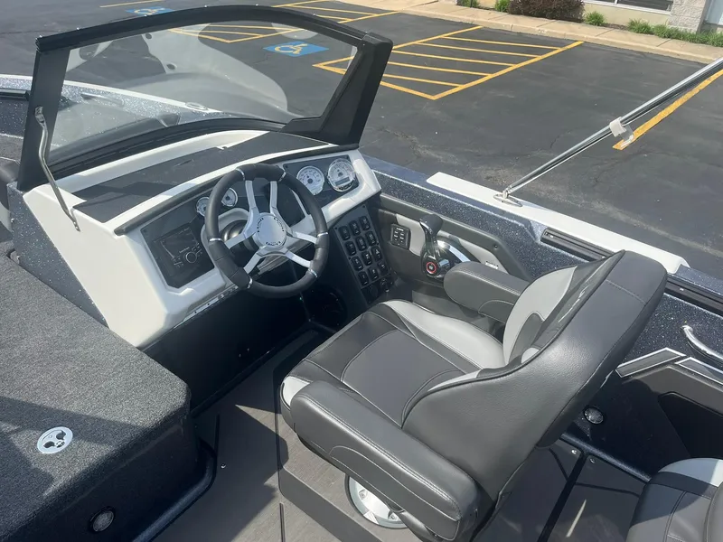 Slide: The Image of 2025 Lund 202 Pro-V GL boat cockpit with steering wheel and comfortable seating. - 15