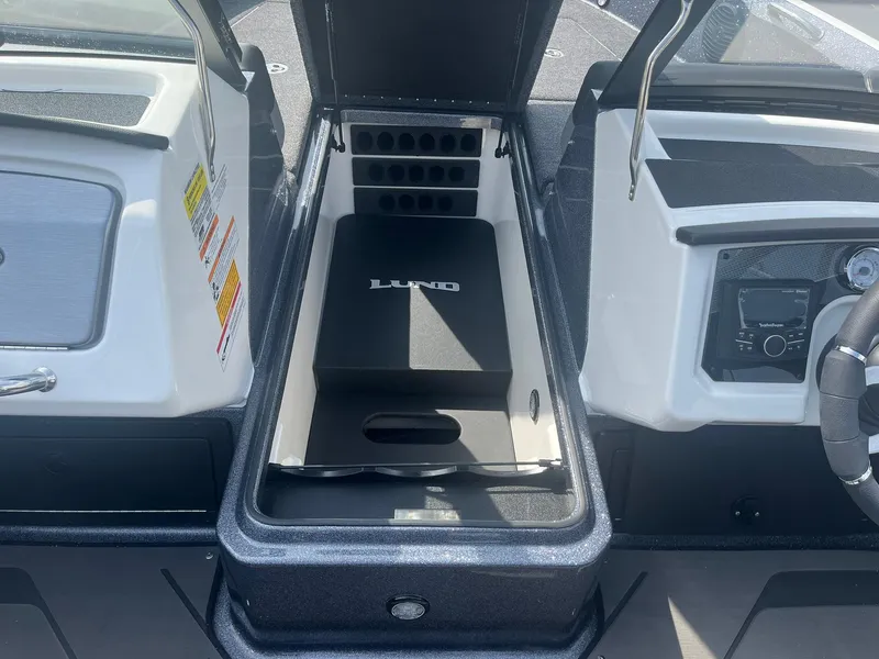 Slide: The Image of 2025 Lund 202 Pro-V GL boat storage compartment with open lid and visible interior features. - 18