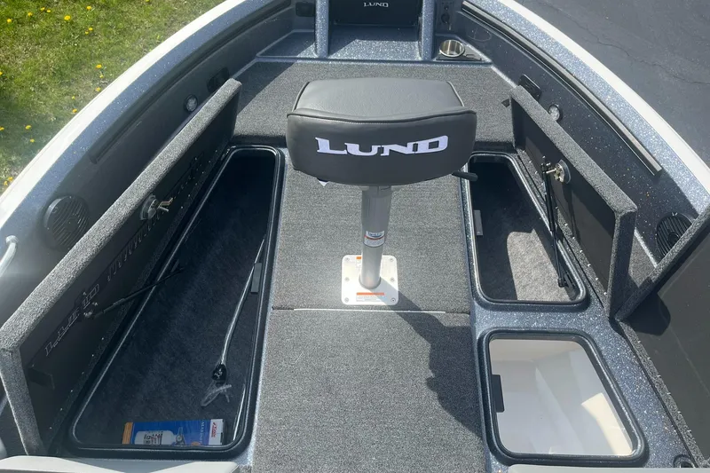 Slide: The Image of 2025 Lund 202 Pro-V GL boat interior with storage compartments and seating. - 21