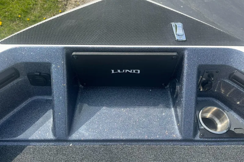 Slide: The Image of 2025 Lund 202 Pro-V GL boat interior with storage compartments and cup holder. - 23