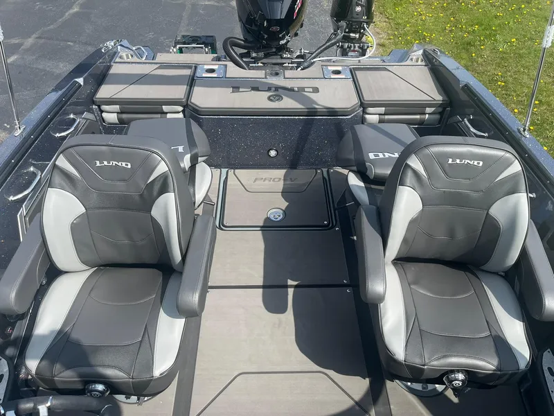 Slide: The Image of 2025 Lund 202 Pro-V GL boat interior with two cushioned seats and storage compartments. - 25