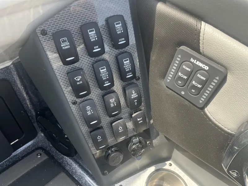 Slide: The Image of Control panel of 2025 Lund 202 Pro-V GL boat with switches and Lenco trim tab controls. - 29
