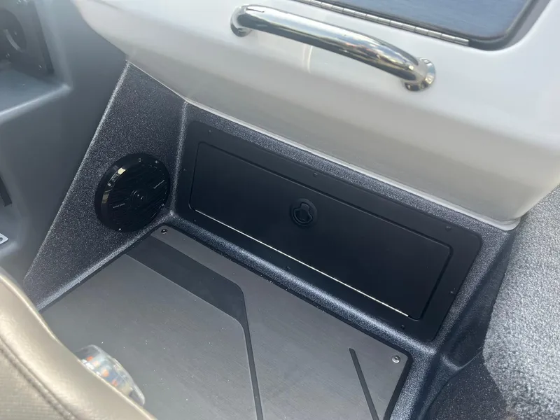 Slide: The Image of 2025 Lund 202 Pro-V GL boat interior, featuring storage compartment and speaker. - 34