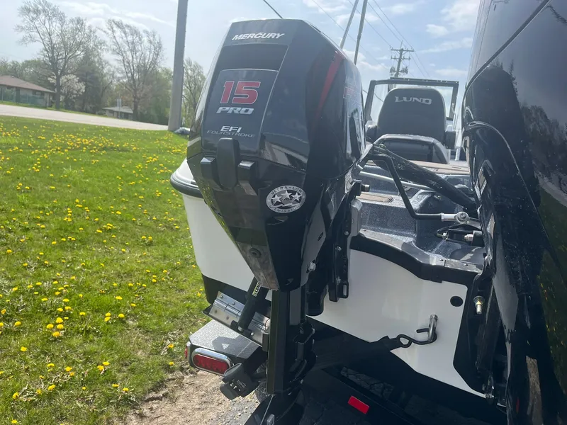 Slide: The Image of 2025 Lund 202 Pro-V GL boat with Mercury 15 Pro outboard motor on grassy area. - 41