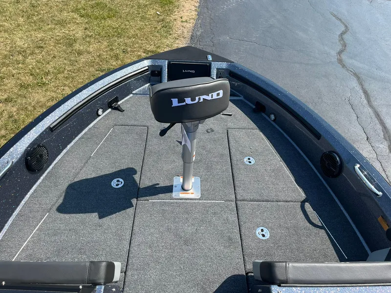 Slide: The Image of 2025 Lund 202 Pro-V GL boat interior with seating and carpeted deck. - 12