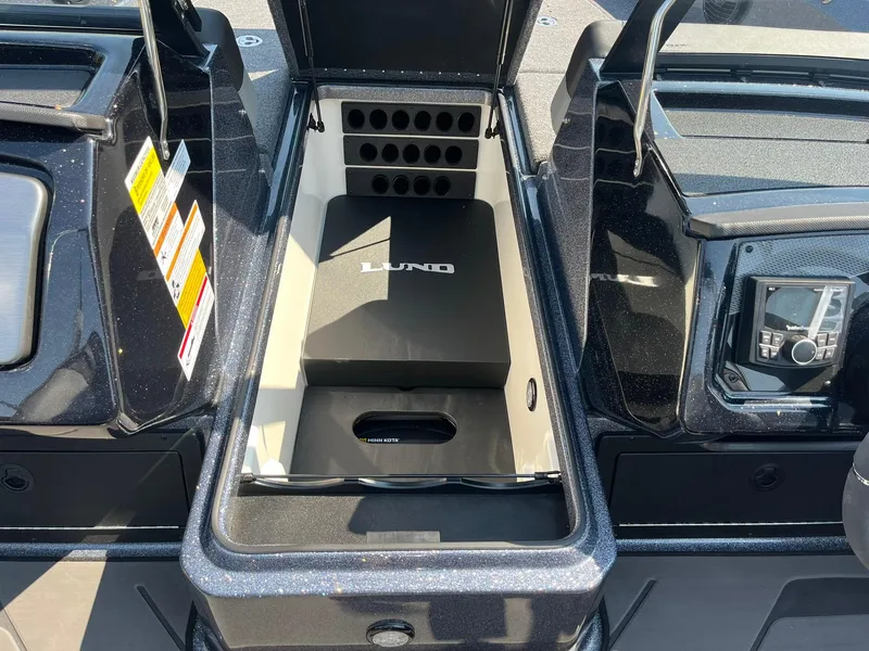 Slide: The Image of 2025 Lund 202 Pro-V GL boat storage compartment with organized interior and control panel. - 14