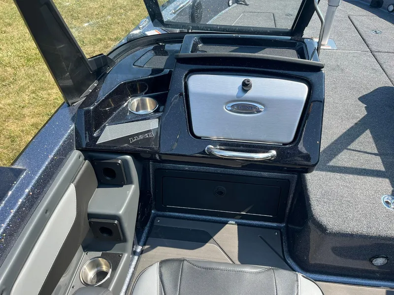Slide: The Image of 2025 Lund 202 Pro-V GL boat interior with storage compartments and cup holders. - 23