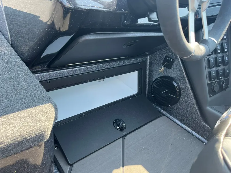 Slide: The Image of 2025 Lund 202 Pro-V GL boat interior, featuring dashboard controls and storage compartment. - 27