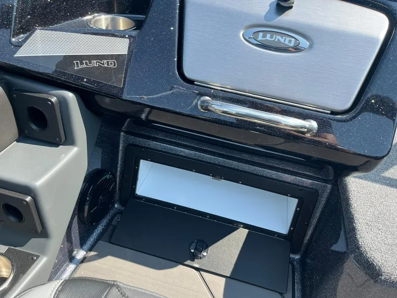 Slide: The Image of 2025 Lund 202 Pro-V GL boat dashboard with storage compartment and cup holder. - 28