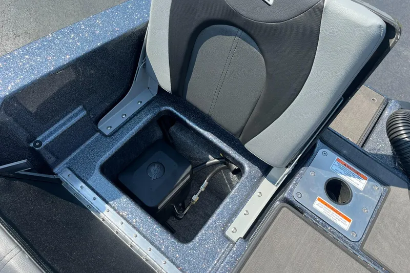 Slide: The Image of 2025 Lund 202 Pro-V GL boat seat with storage compartment and safety labels. - 38