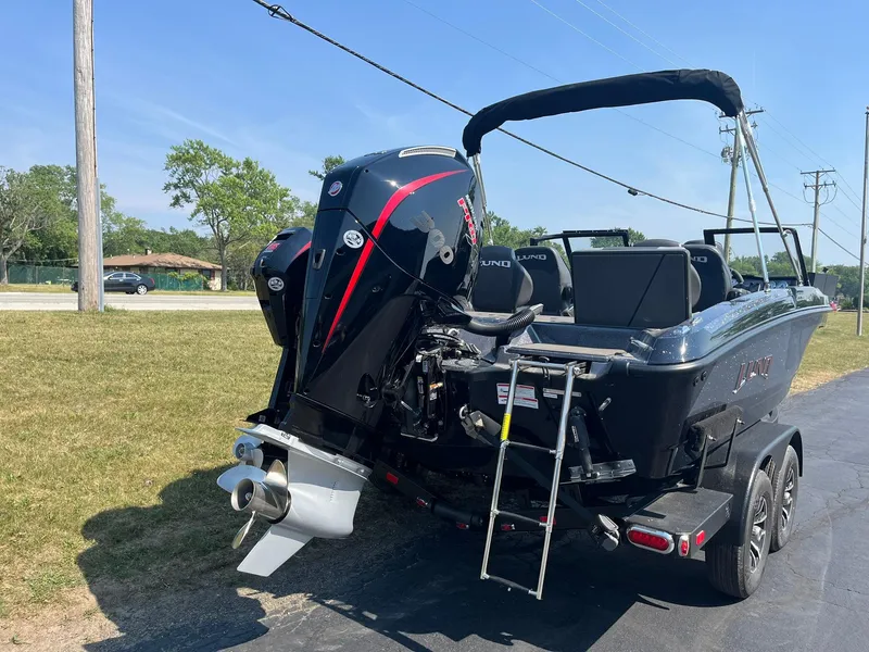 Slide: The Image of 2025 Lund 202 Pro-V GL boat with powerful outboard motor and trailer, parked outdoors. - 44