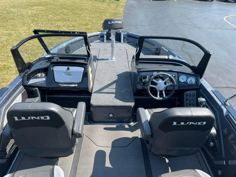 Slide: The Image of 2025 Lund 202 Pro-V GL boat interior with steering console and seating. - 7