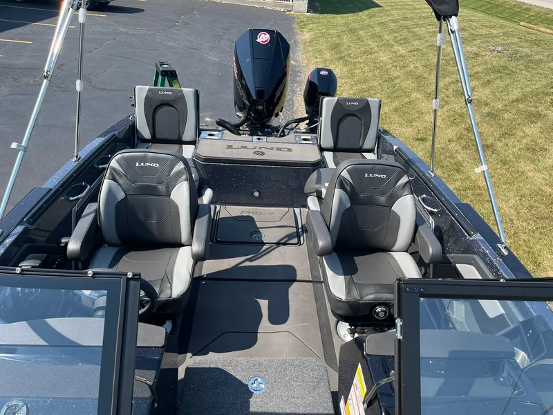 Slide: The Image of 2025 Lund 202 Pro-V GL boat interior with four seats and a powerful outboard motor. - 8