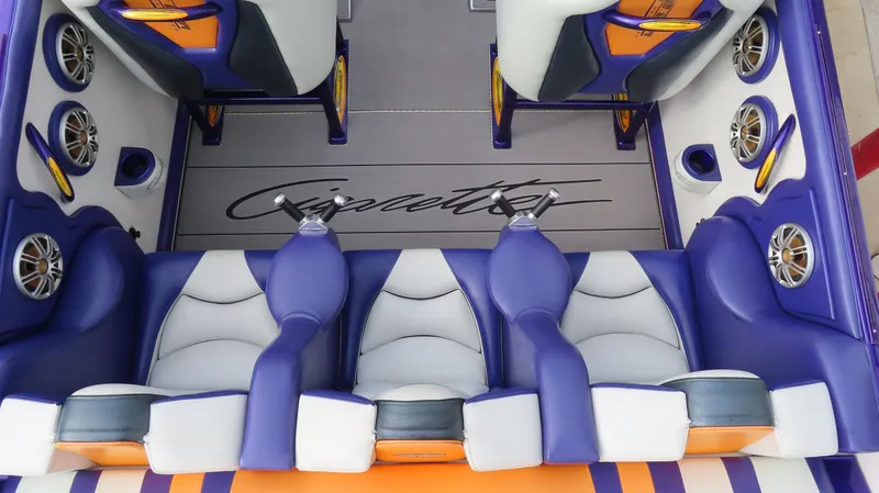 Slide: The Image of Interior of a 2005 Cigarette 39' Top Gun Unlimited boat with purple and white seating. - 10