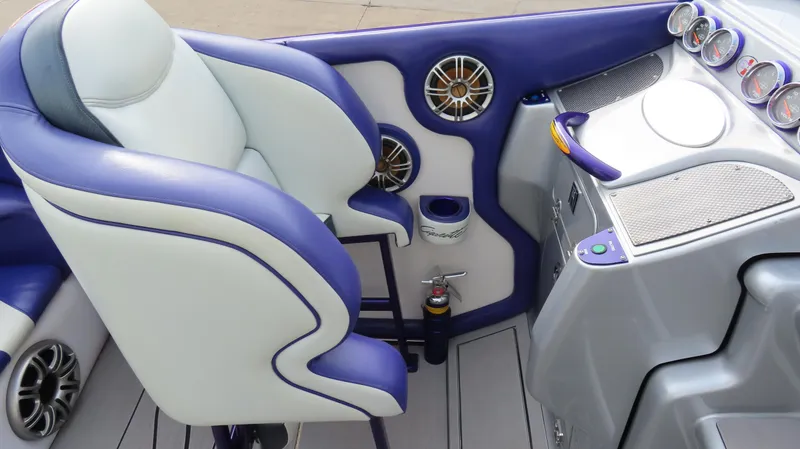Slide: The Image of 2005 Cigarette 39' Top Gun Unlimited boat interior with blue and white seating, dashboard, and speakers. - 12
