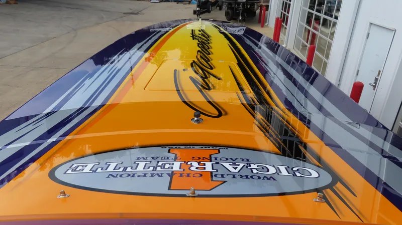Slide: The Image of 2005 Cigarette 39' Top Gun Unlimited boat with vibrant orange and purple design. - 16