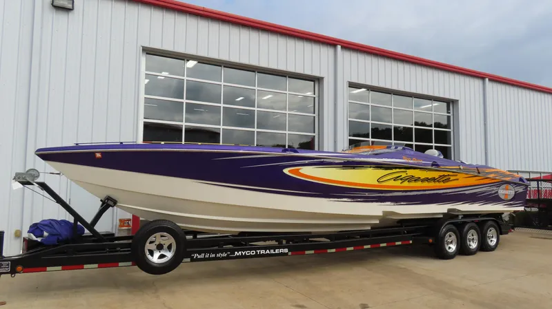 Slide: The Image of 2005 Cigarette 39' Top Gun Unlimited boat on trailer outside a garage. - 2