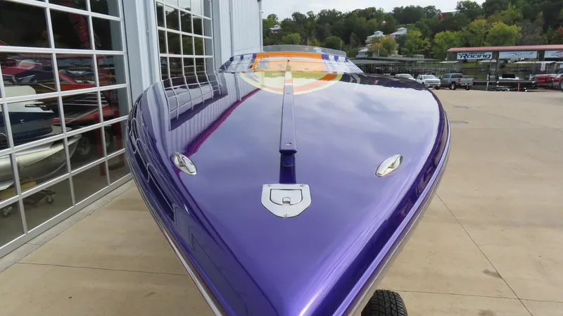 Slide: The Image of 2005 Cigarette 39' Top Gun Unlimited boat with sleek purple hull, parked outdoors. - 3