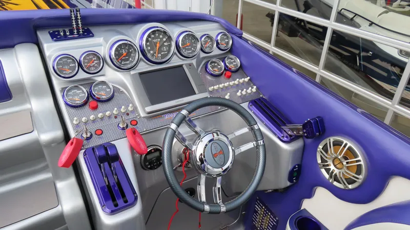 Slide: The Image of 2005 Cigarette 39' Top Gun Unlimited boat dashboard with gauges and steering wheel. - 32