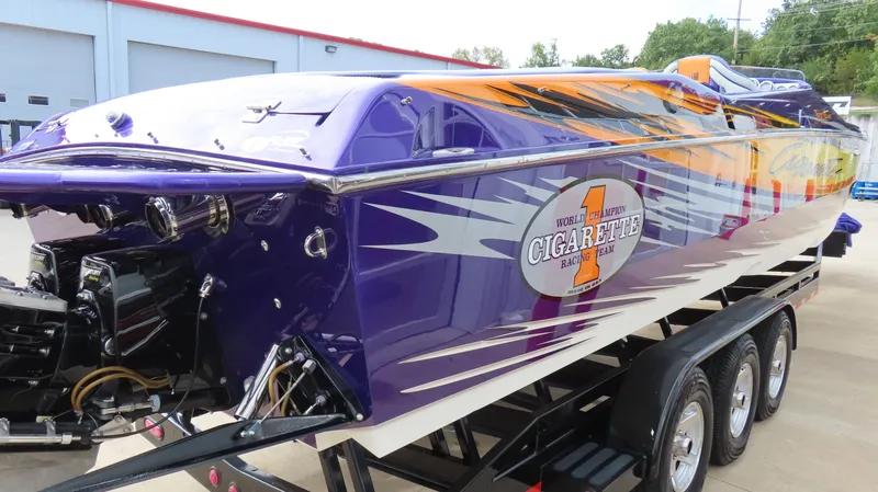 Slide: The Image of 2005 Cigarette 39' Top Gun Unlimited speedboat with vibrant purple and orange design on trailer. - 5