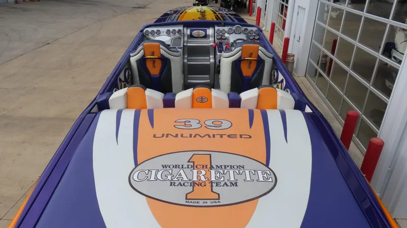 Slide: The Image of 2005 Cigarette 39' Top Gun Unlimited speedboat with vibrant orange and purple design. - 8