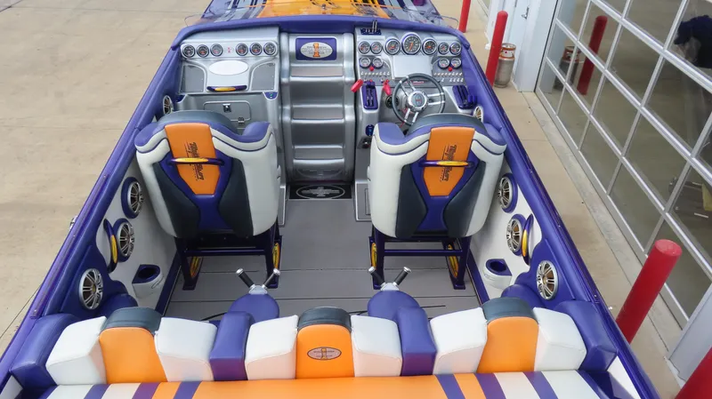 Slide: The Image of 2005 Cigarette 39' Top Gun Unlimited boat interior with vibrant seating and advanced dashboard controls. - 9