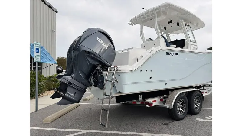 Slide: The Image of 2025 Sea Fox 288 Commander boat on trailer with Yamaha outboard motor in parking lot. - 4