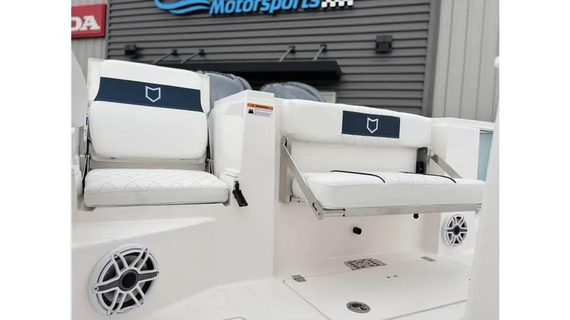 Slide: The Image of 2025 Sea Fox 288 Commander boat seats with speakers, displayed at a motorsports showroom. - 8
