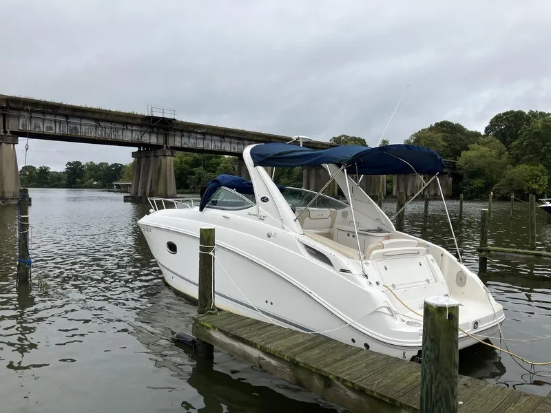 The Image of 2012 Sea Ray 280 Sundancer docked by a bridge on a cloudy day. - 1