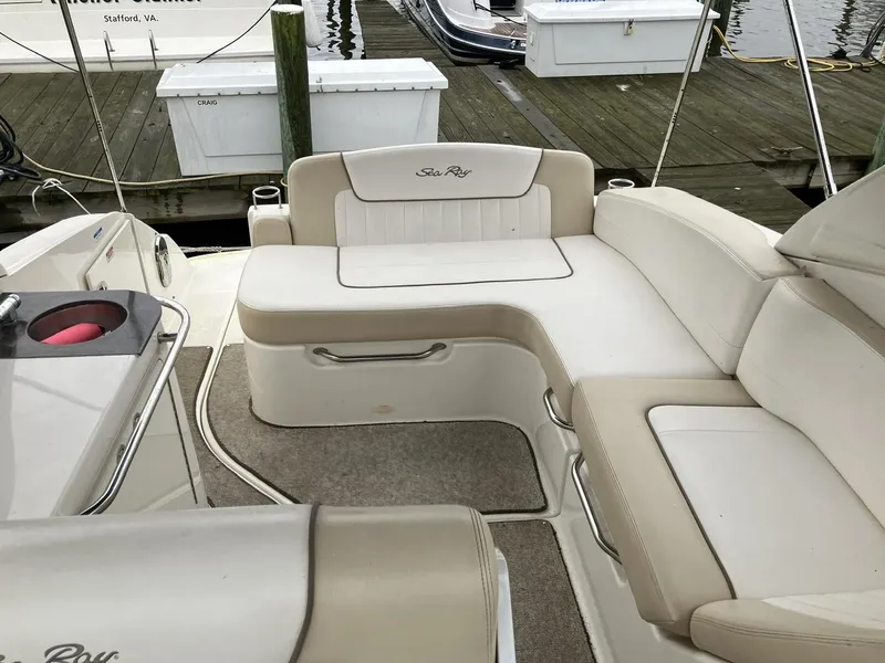 Slide: The Image of 2012 Sea Ray 280 Sundancer boat interior with beige seating and dock view. - 10