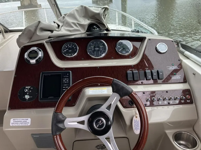 Slide: The Image of Dashboard of a 2012 Sea Ray 280 Sundancer boat with gauges and controls. - 13