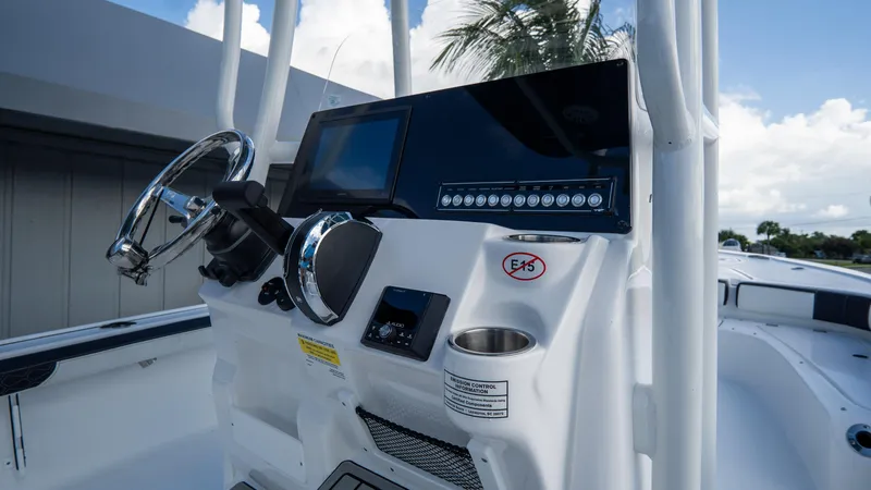 Slide: The Image of 2025 Tidewater 2300 Carolina Bay boat console with steering wheel and digital display. - 11