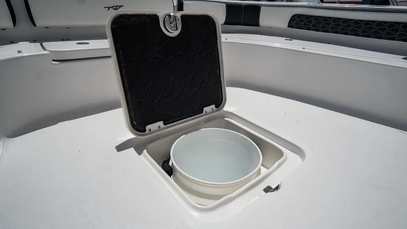 Slide: The Image of 2025 Tidewater 2300 Carolina Bay boat with open storage compartment and bucket. - 18