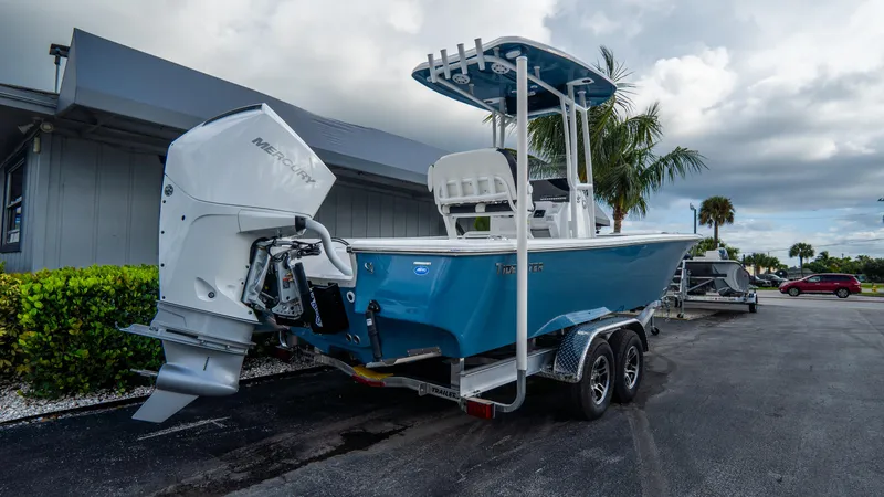 Slide: The Image of 2025 Tidewater 2300 Carolina Bay boat on trailer, blue hull, parked outdoors. - 3