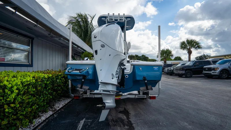 Slide: The Image of 2025 Tidewater 2300 Carolina Bay boat, rear view, parked outdoors under cloudy sky. - 4