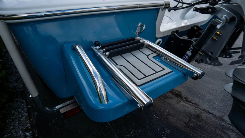 Slide: The Image of 2025 Tidewater 2300 Carolina Bay boat with stainless steel swim ladder and blue hull. - 5
