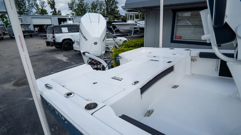 Slide: The Image of 2025 Tidewater 2300 Carolina Bay boat, white deck, outboard motor, parked outdoors. - 6