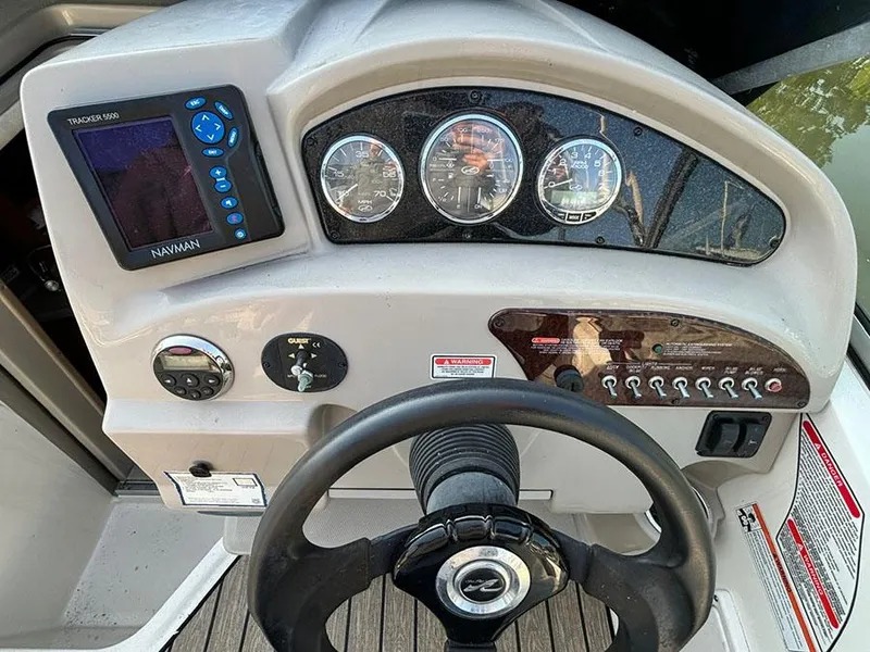 Slide: The Image of Dashboard of a 2006 Sea Ray 240 Sundancer boat with steering wheel and gauges. - 10