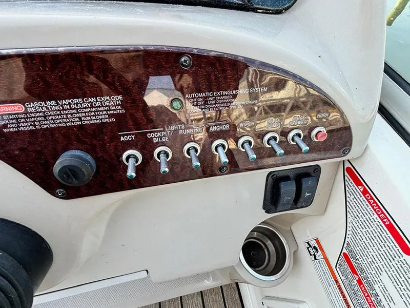 Slide: The Image of Control panel of a 2006 Sea Ray 240 Sundancer boat with various switches and warnings. - 11