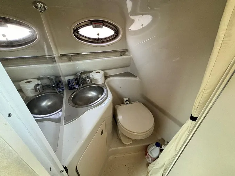 Slide: The Image of 2006 Sea Ray 240 Sundancer bathroom with sink, toilet, and porthole window. - 20
