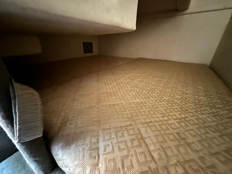 Slide: The Image of 2006 Sea Ray 240 Sundancer cabin interior with beige patterned bedding. - 21