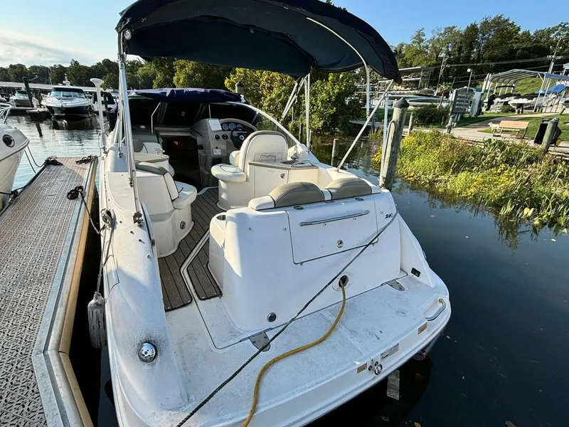 Slide: The Image of 2006 Sea Ray 240 Sundancer docked, featuring spacious seating and canopy. - 3