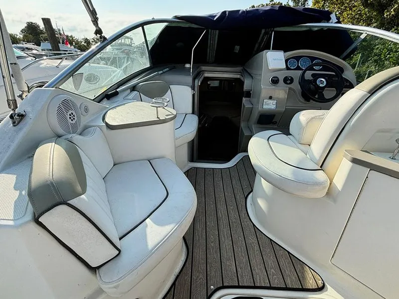 Slide: The Image of 2006 Sea Ray 240 Sundancer interior with plush seating and modern dashboard. - 7