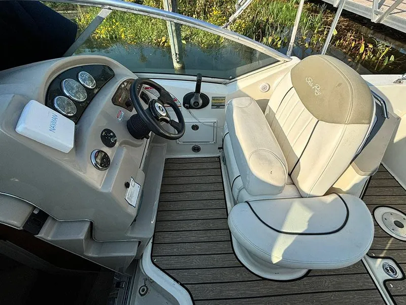 Slide: The Image of 2006 Sea Ray 240 Sundancer cockpit with steering wheel and cushioned seating. - 9